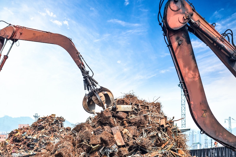 Crane picking up pile of scrap metal