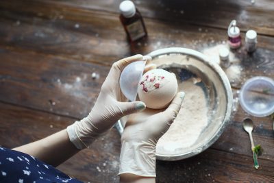 Preparation of bath bombs. Ingredients and floral decor on a wooden vintage table.