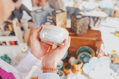 Woman selecting handmade crafts at a flea market